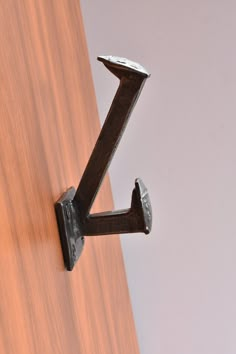 a close up of a door handle on a wooden door with white walls in the background