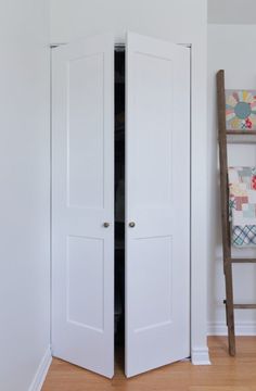 an open closet door in a white room