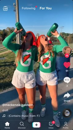 two girls wearing green and white cheerleader outfits