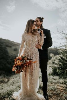 a newly married couple standing in the mountains