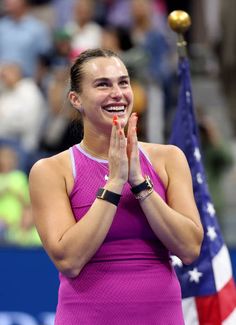 a female tennis player is smiling and clapping