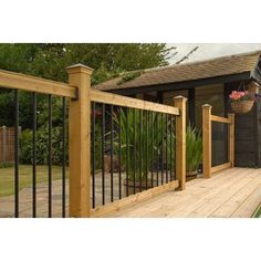 a wooden deck with wrought iron railings and potted plants on the other side