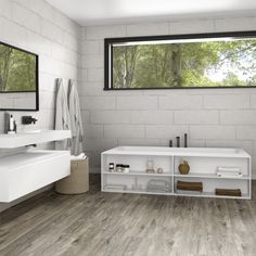 a white bathroom with wood floors and large windows