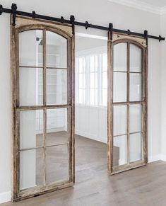 an open window in the middle of a room with wooden floors and white walls,