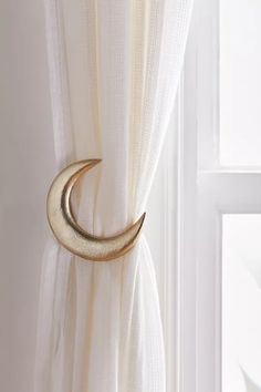 a curtain with a gold crescent hanging on it's side next to a window