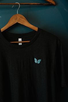 softest tee with the prettiest butterfly embroidery🦋 available on a beige or black tee in a variety of sizes. also available on a white or black sweatshirt! perfect to dress up or down. prefer a sweatshirt? click here: https://www.etsy.com/listing/821856421/butterfly-embroidery-sweatshirt?ref=reviews don't see the size or color you're looking for? contact me for restocks! specifications: -premium pre-shrunk t-shirts source is bella & canvas and is 100% no sweatshops & eco-friendly -90% Airlume combed and ring-spun cotton, 10% poly -comes in unisex sizing, swipe to last image for sizing guide -butterfly embroidery size is 29.2 mmx47 mm -to best maintain embroidery, wash cold & air dry -available to ship in 1-3 business days.  please don't hesitate to reach out if you have any questions🌸 t Cheap Embroidered Black T-shirt, Cheap Black T-shirt With Custom Embroidery, Most Beautiful Butterfly, Butterfly Shirts, Butterfly Embroidery, Embroidery Sweatshirt, Black Sweatshirt, Cozy Sweatshirts, White Sweatshirt