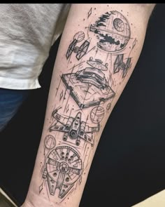 a person with a tattoo on their arm has a spaceship and star wars vehicles in the background