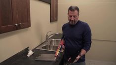 a man standing in front of a kitchen sink