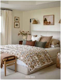 a bed with pillows and blankets on top of it in a bedroom next to a window