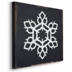 a black and white snowflake is hanging on a wooden block with chalk paint