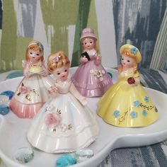 four little princess figurines are sitting on a tray