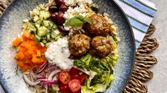 a blue plate topped with meatballs and vegetables