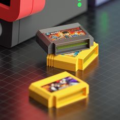 an old nintendo game console sitting on top of a table next to a yellow object