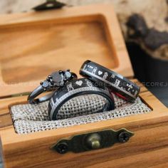 two wedding rings sitting in a wooden box