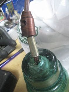 a close up of a glass bottle with a screwdriver in it