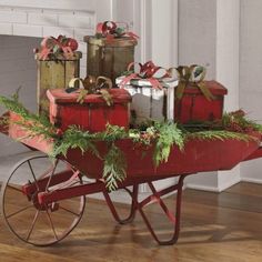 a red wagon filled with presents on top of a hard wood floor next to a fire place