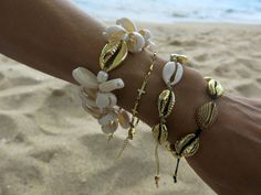 This beautiful cowrie set bracelet is made with natural white cowrie shells, natural gold cowrie shells, big 24k gold plated cowrie shell, freshwater pearls, 24k gold plated beads and beige silk cord. Bead size: shell 1,5 - 2 cm / 0,6 - 0,8 inch.; gold shell 2,5 cm/ 1 inch.; gold plated beads 0,3 cm /0,1 inch. Your bracelet comes gift wrapped and shipped via priority registered air mail with tracking info available. Feel free to ask me any questions! Thanks for visiting and happy shopping :) Gold Cowrie Shell As Gift, White Cowrie Shell Bracelet, Handmade Gold Bracelets For Vacation, Gold Shell Bracelets For Gift, Gold Shell Bracelets For Gifts, Gold Shell-shaped Bracelet For Vacation, Gold Shell Beaded Bracelets As Gift, Handmade Gold Beaded Bracelets For Vacation, Gold Shell Bracelet For Vacation