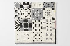 a black and white patchwork quilt hanging on a wall