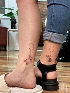 two people with tattoos on their feet and one has a balloon attached to the ankle