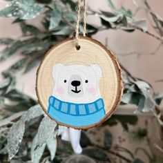 a wooden ornament with a polar bear on it's face hanging from a tree