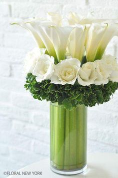 white flowers in a green vase on a table