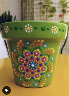 a green flower pot sitting on top of a yellow table