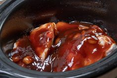 the meat is covered with sauce in the slow cooker