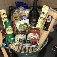 a bowl filled with pasta, cheese and other food items next to a bottle of wine