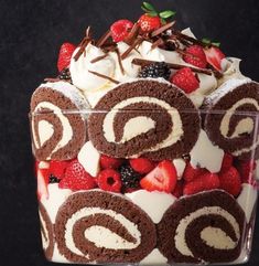 a chocolate cake with whipped cream and strawberries in the center on a black background