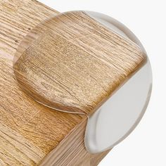 a close up of a wooden table with a white plate on it and an object in the background