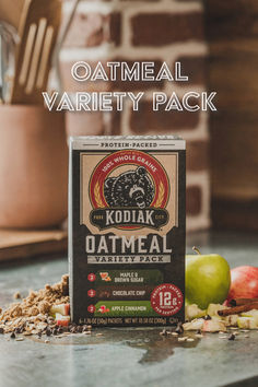 an oatmeal variety pack on a table with apples and other food items