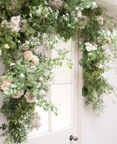 the door is decorated with greenery and flowers