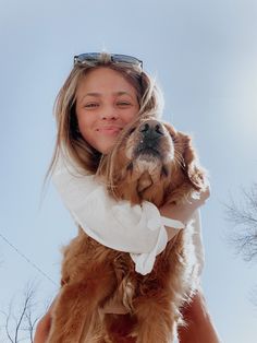 a woman holding a dog in her arms