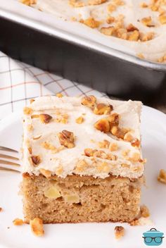 a close up of a piece of cake on a plate with a fork and pan in the background