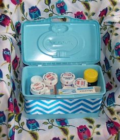 an open blue case with various items in it on a floral print chair cushioned background