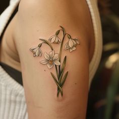 a woman with a tattoo on her arm has flowers in the shape of lilyes