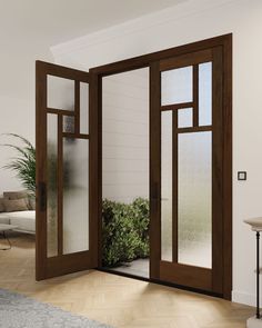 an open door to a living room with potted plants on the floor and glass doors