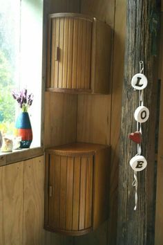 a bathroom with wooden walls and flooring next to a potted plant on the window sill