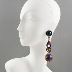 This is part of Chairish’s Costume Jewelry assortment.  These stunning futuristic dangling clip-on earrings feature a cool Space Age 1980s design, with shoulder duster dangle articulated wired elements complimented with rings and huge beads. The multicolor enameled metal has fall colors in purple, saffron, burgundy, and green forest. There is no visible maker's mark. It is in good condition, with minor scratches on the metal paint. Measurements: 1.25 in. wide (3.2 cm) x 4.75 in. long (12 cm).  P Modern Evening Clip-on Dangle Earrings, Modern Dangle Clip-on Earrings For Evening, Modern Evening Dangle Clip-on Earrings, Cyberspace Earrings, Space Age Jewelry, Retro Dangle Clip-on Earrings, Multicolor Metal Clip-on Earrings, Luxury Modernist Purple Jewelry, 1980s Design