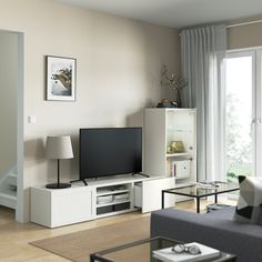 a living room filled with furniture and a flat screen tv on top of a stand