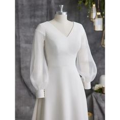 a white dress on a mannequin with long sleeves