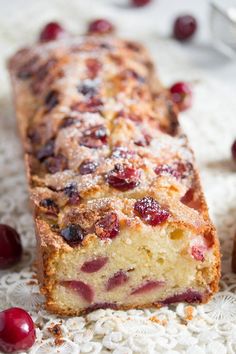 cranberry bread with powdered sugar and cherries on a doily, ready to be eaten