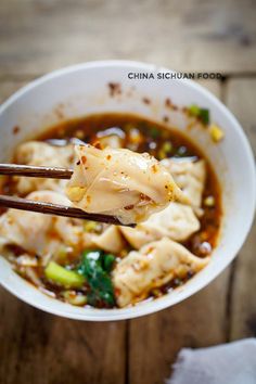 a close up of a bowl of food with chopsticks