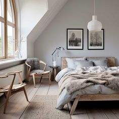 a bedroom with a bed, chair and pictures on the wall