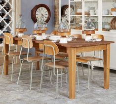 a dining room table with chairs and a clock on the wall in the back ground