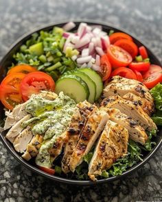 a salad with chicken, cucumber and tomatoes