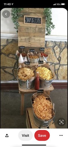 several buckets filled with food sitting on top of a wooden table next to a sign