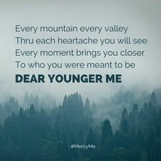 the words dear younger me are written in green and black on a foggy forest background