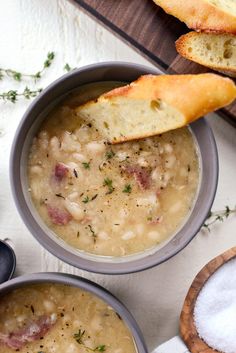 two bowls filled with soup next to bread