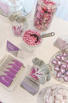 candy bar with pink and silver candies, chocolate bars, and other items on the table